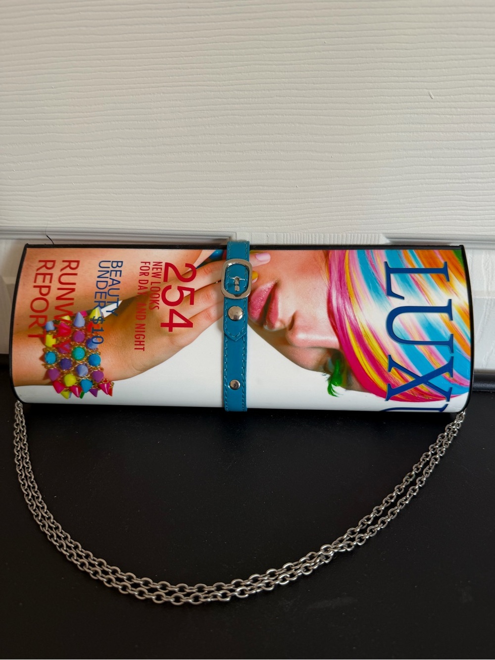 Hard Case Clutch styled to look like magazine. Chain strap. Read